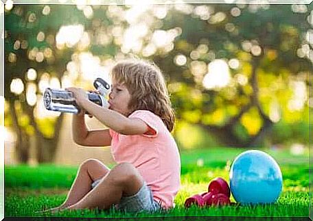 A child who drinks water after playing sports.