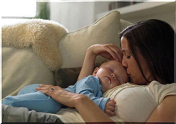 Mom kissing her sleeping baby in her arms