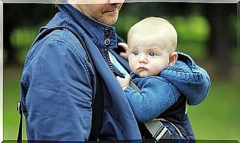 A dad with his child in a baby carrier. 