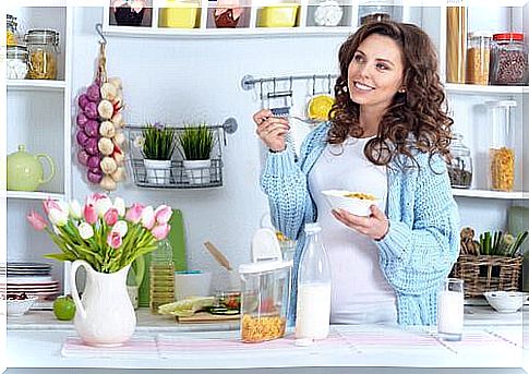 A pregnant woman eats breakfast