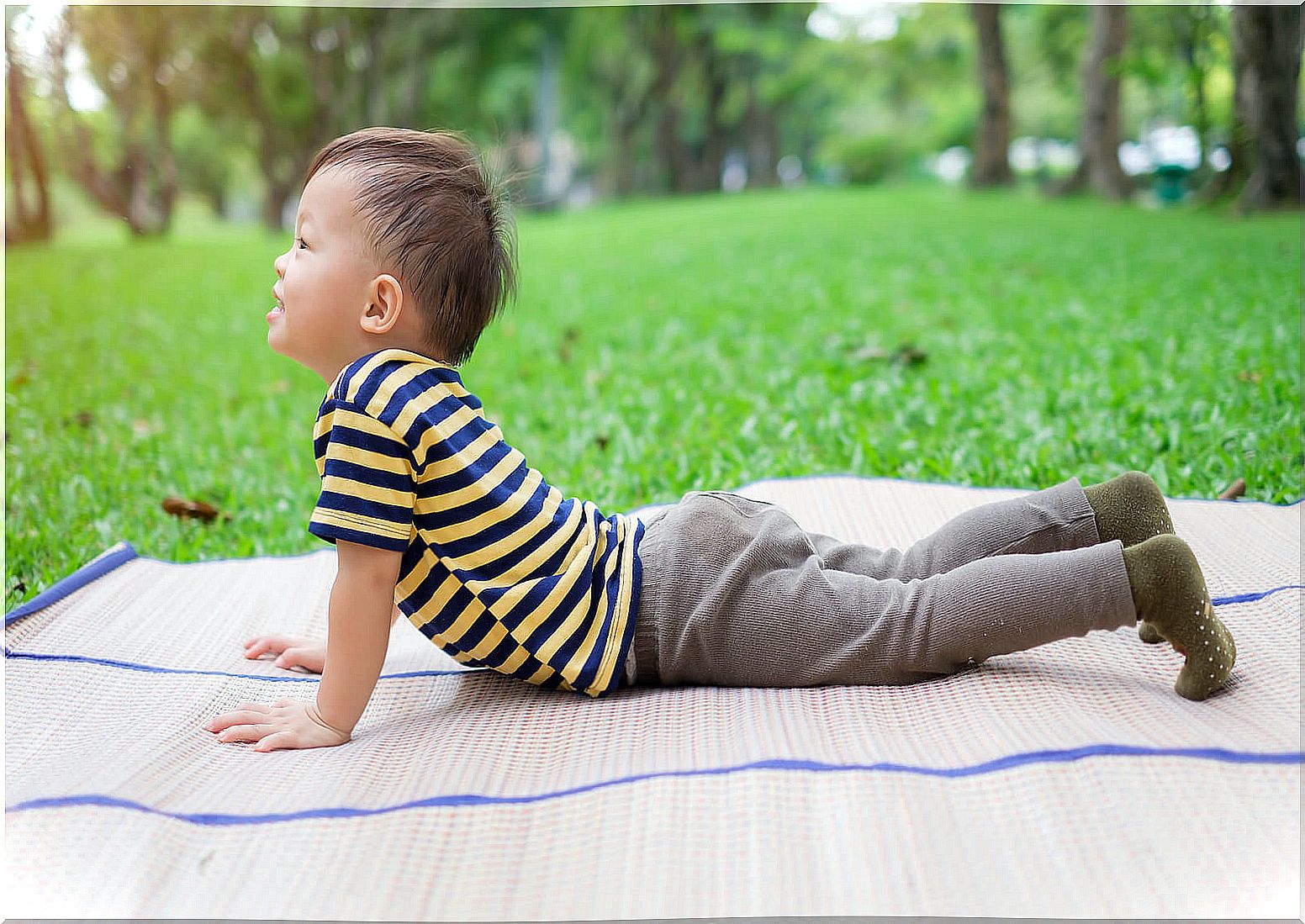 Child lying on the floor doing upward facing dog pose.