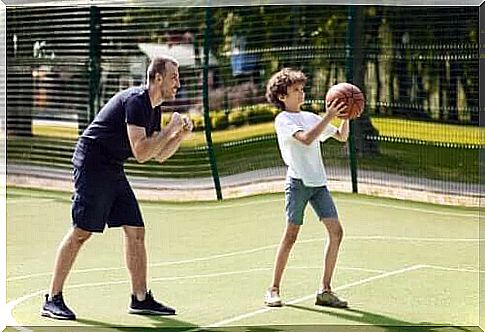 A father who teaches his son to play basketball. 