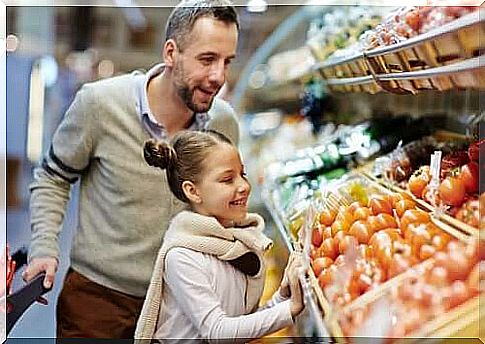 father and daughter in front of vegetables