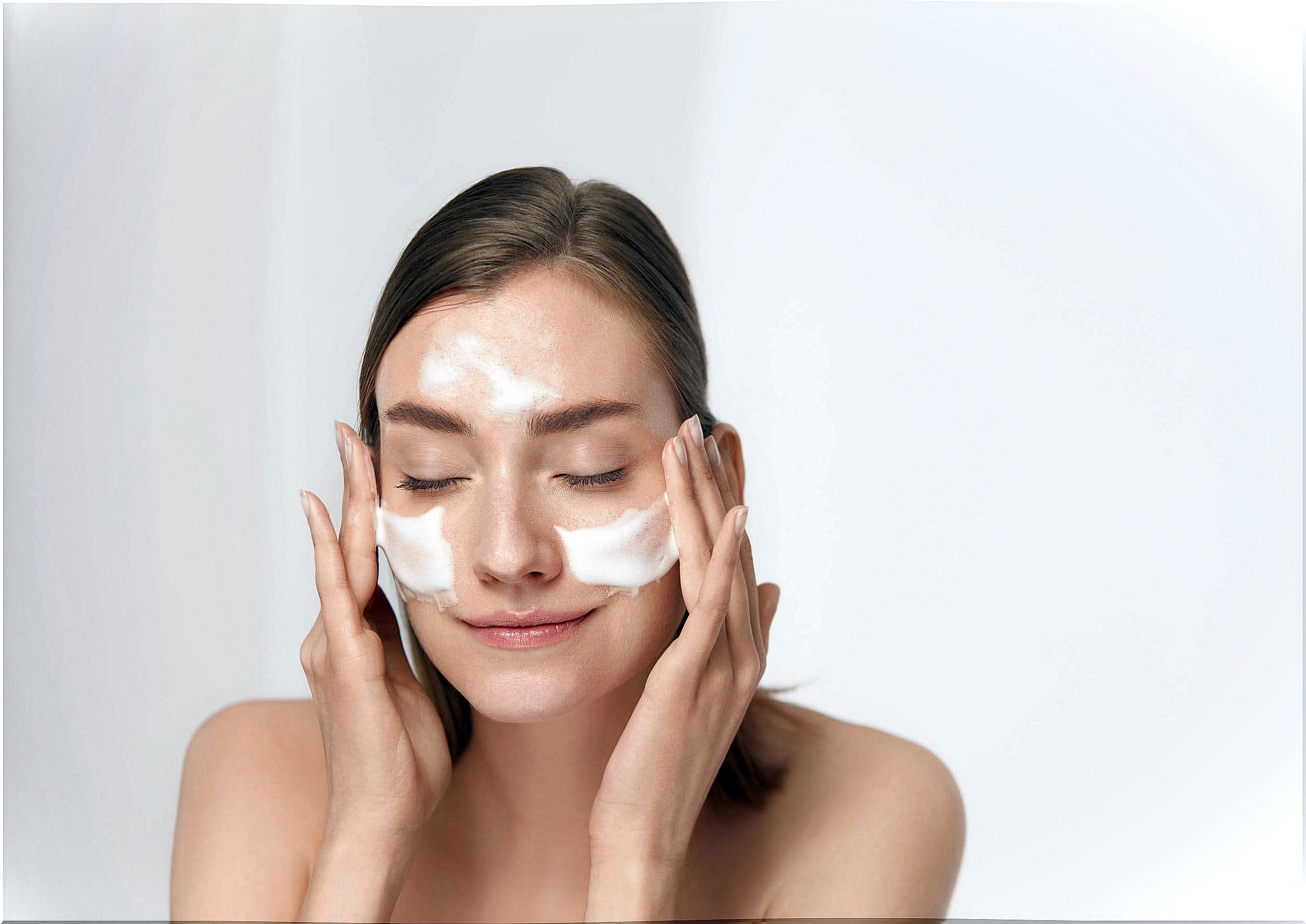 Woman applying moisturizer.