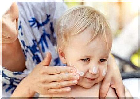 Applying sunscreen to a child's face. 