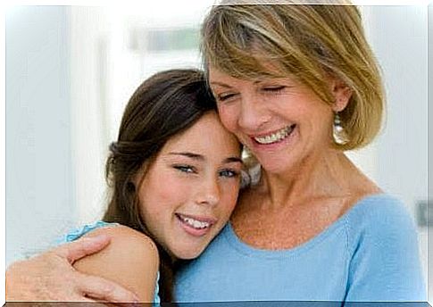 A teenage girl in her mother's arms. 