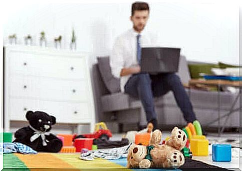 man telecommuting with toys in foreground