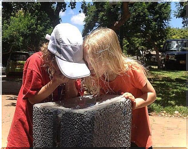 Two children drinking water