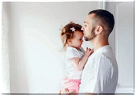 A father holding his daughter.