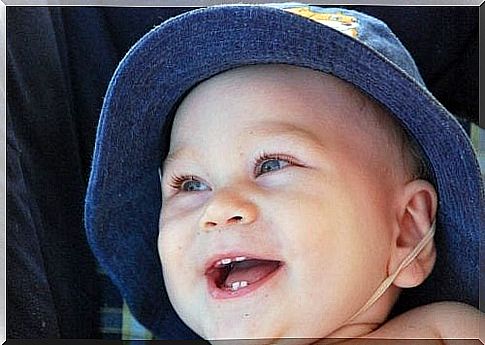 A smiling baby with his first teeth